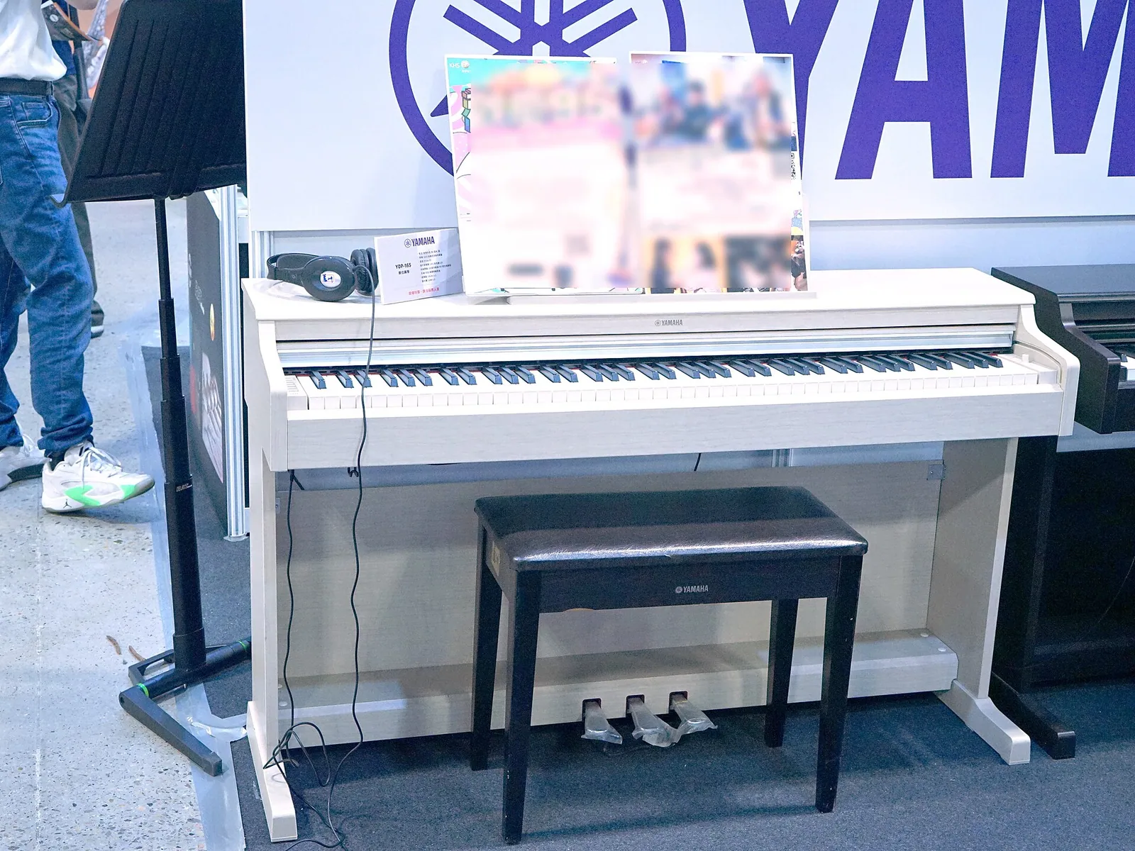 Piano digital Yamaha Arius com móvel branco, três pedais e banqueta